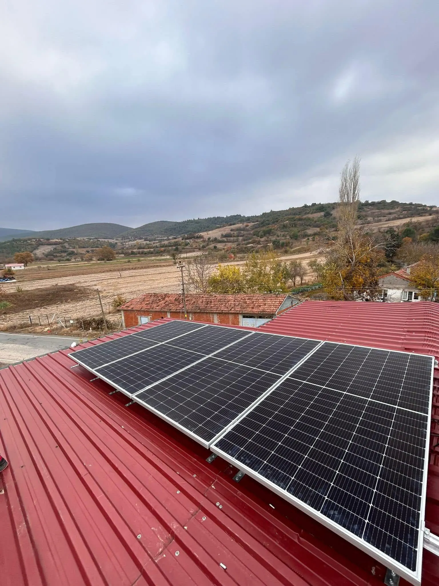 Kırmızı metal çatı üzeri güneş paneli kurulumu